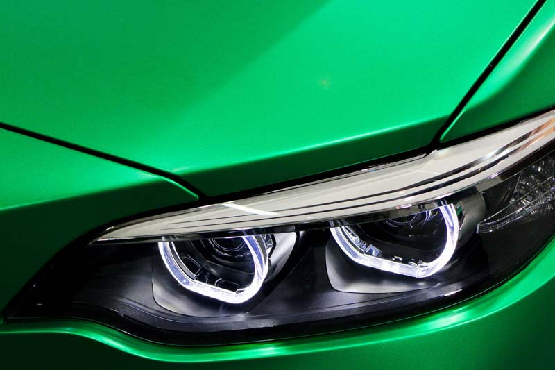 Close-up of LED headlights on a green car