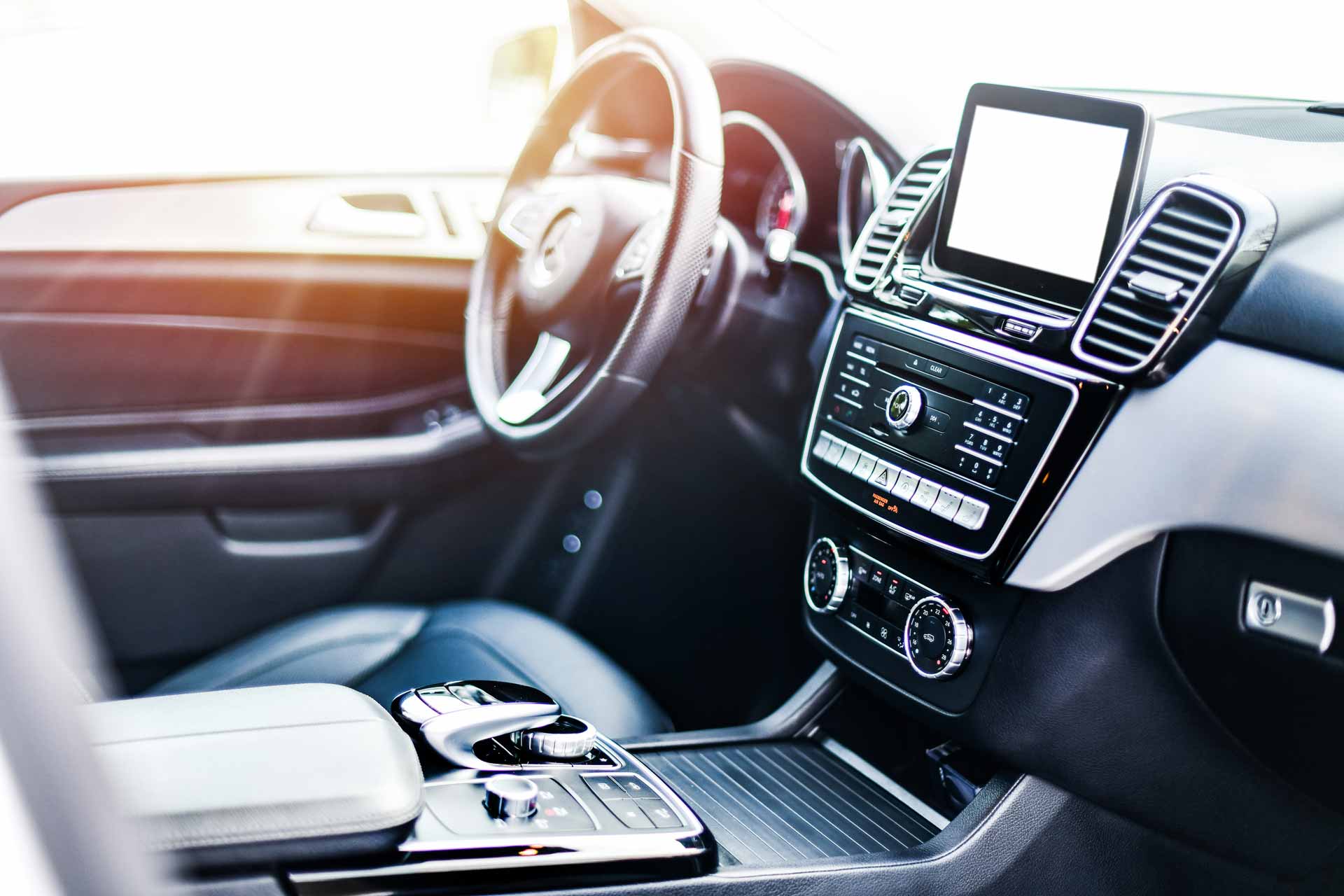 Interior view of car, luxury car steering wheel and clean dashboard with display or monitor screen